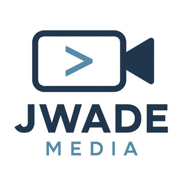 Logo for JWade Media featuring a stylized dark blue video camera icon with a light blue greater-than symbol inside the lens area. Below the icon, the text ‘JWADE’ appears in bold dark blue capital letters, with the word ‘MEDIA’ in smaller light blue capita